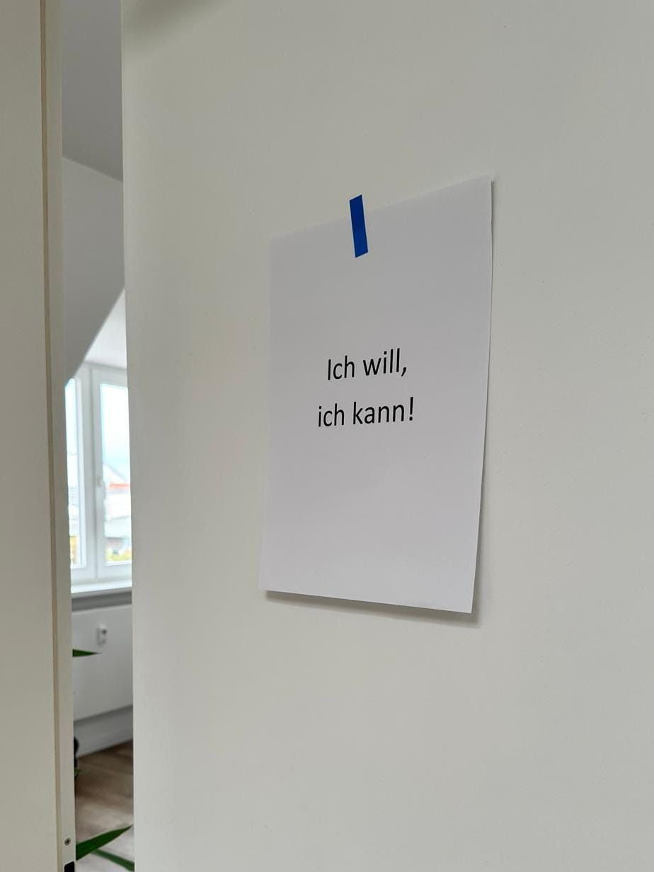 Ein weißes Blatt Papier mit blauem Klebestreifen an einer Tür, darauf steht: Ich will, ich kann!